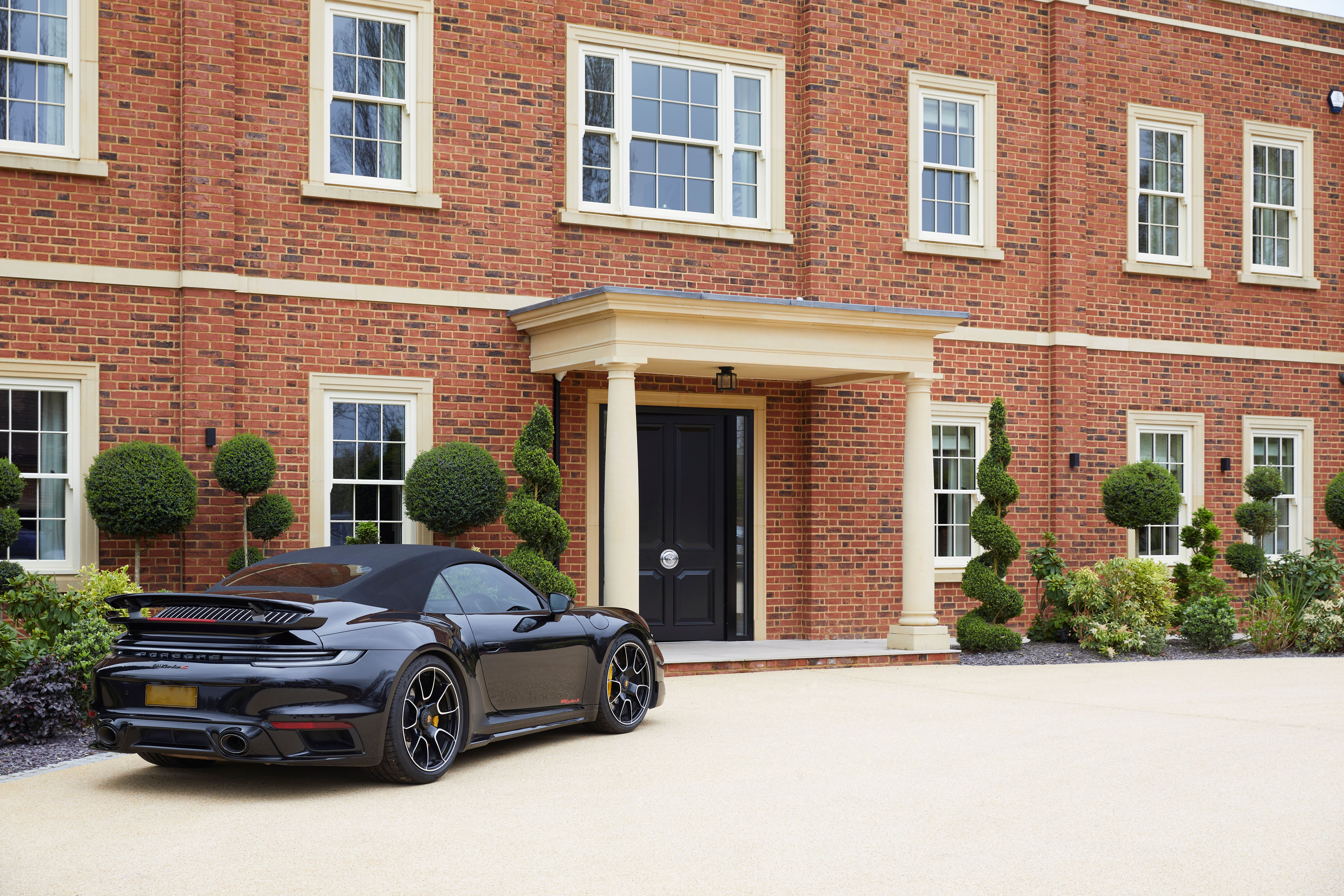 A high-value house with a car parked outside.