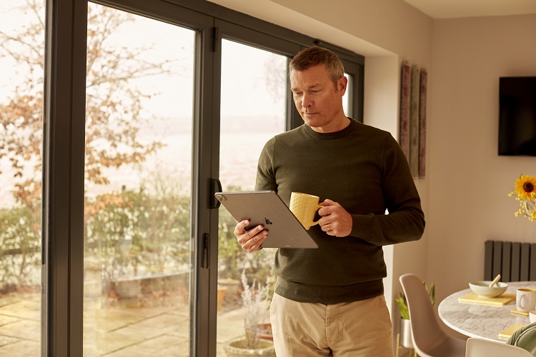 Man using interactive tablet whilst drinking coffee