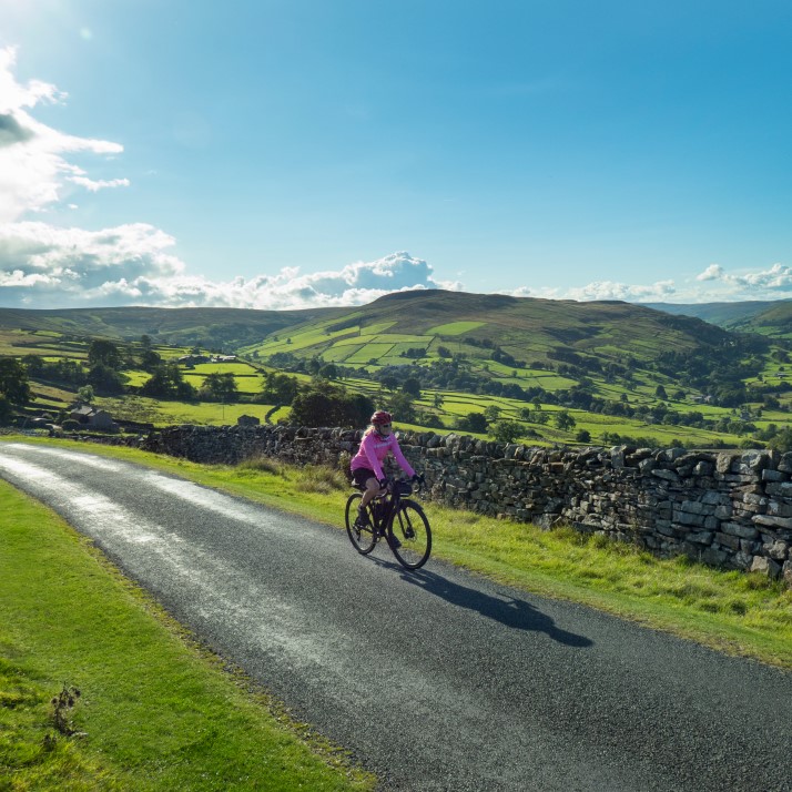 Lady riding bicycle through countryside