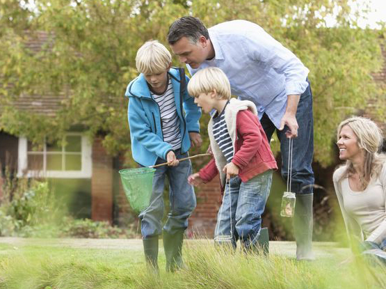 father and son playing in a pond