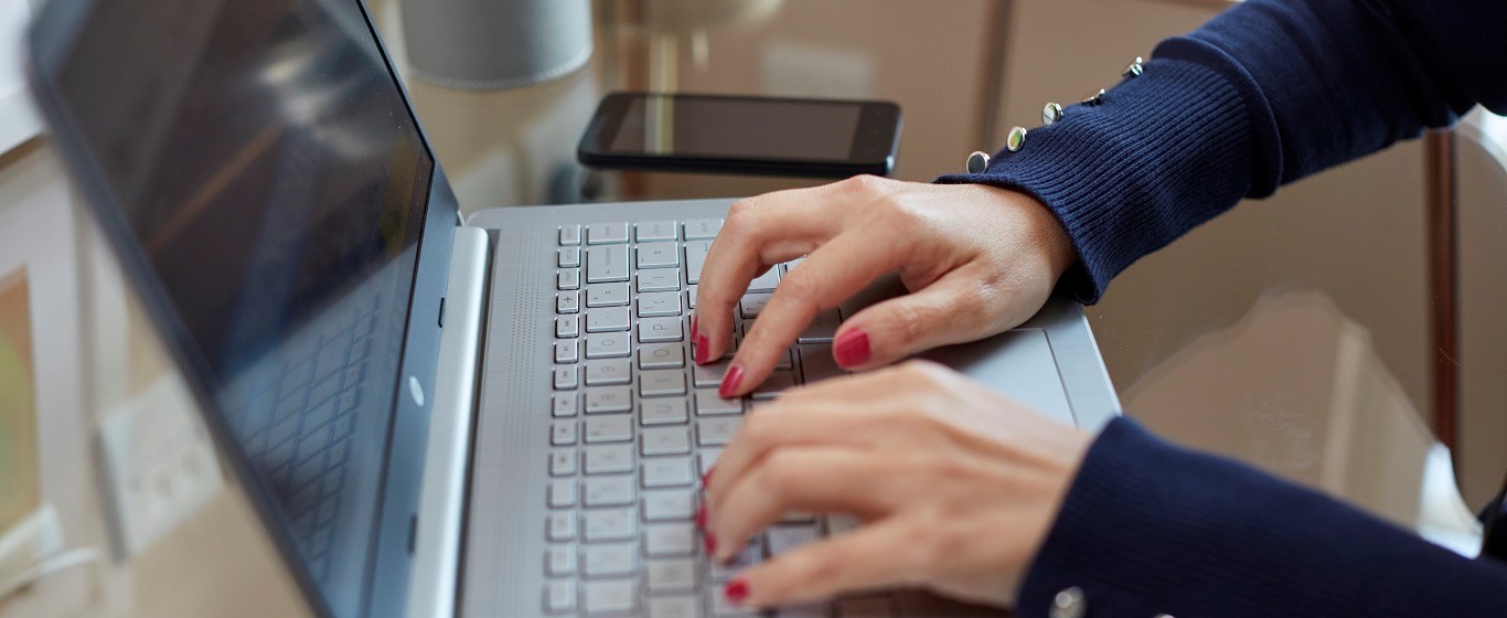 hands typing on a laptop