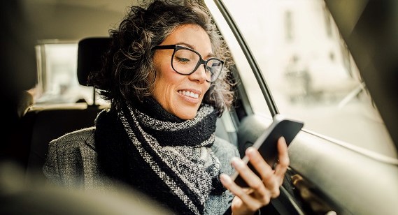 lady in a car looking at her mobile phone