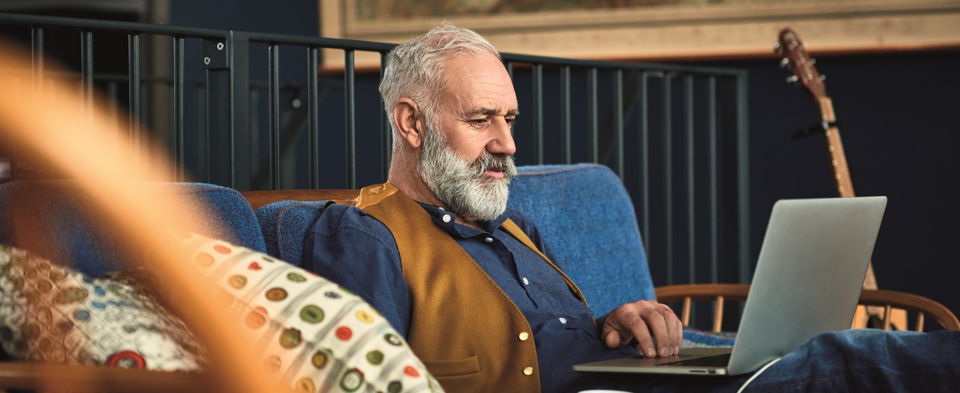 Senior man working on laptop at home